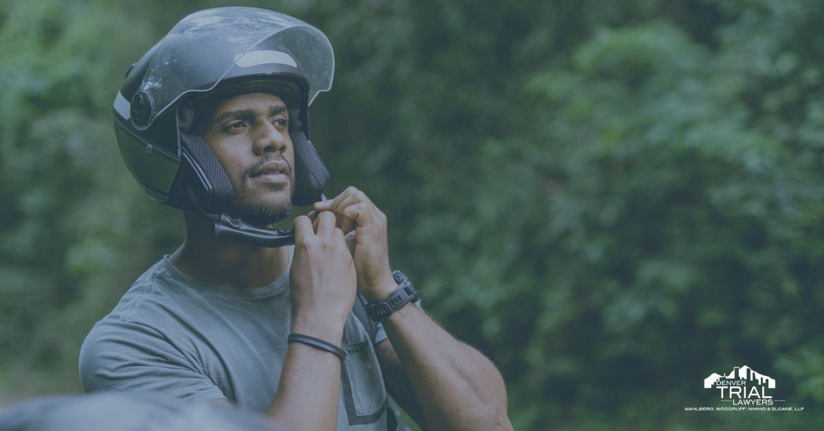 Man putting on a motorcycle helmet.